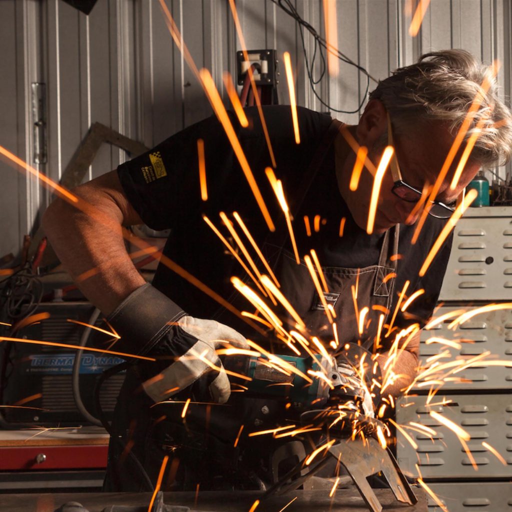 Jeff Zischke grinding steel in his studio